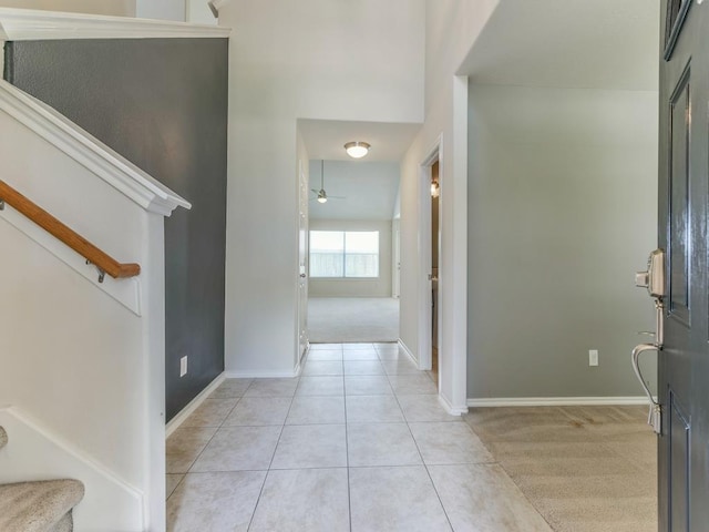 24247 Silversmith Ln, Katy, TX 77493 - foyer featuring stairs, a ceiling fan, light tile patterned flooring, light colored carpet, and baseboards