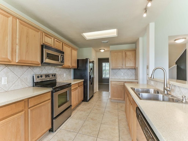 24247 Silversmith Ln, Katy, TX 77493 - kitchen with stainless steel appliances, a sink, decorative backsplash, light tile patterned flooring, and light countertops