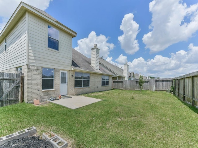 24247 Silversmith Ln, Katy, TX 77493 - rear view of house with brick siding, a patio area, and a chimney
