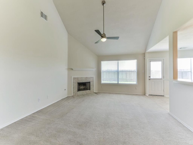 24247 Silversmith Ln, Katy, TX 77493 - unfurnished living room featuring light colored carpet, a ceiling fan, a tile fireplace, baseboards, and high vaulted ceiling