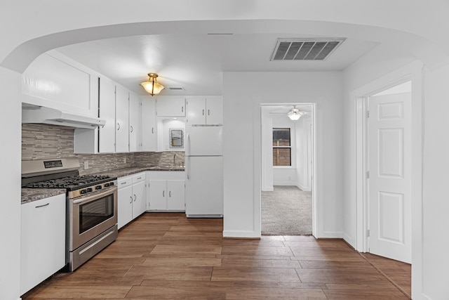 512 Gale St, Houston, TX 77009 - kitchen with stainless steel range with gas cooktop, freestanding refrigerator, under cabinet range hood, white cabinets, and a sink