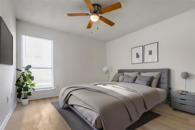 10051 Westpark Dr Unit 274, Houston, TX 77042 - bedroom with baseboards, light wood-style floors, and ceiling fan