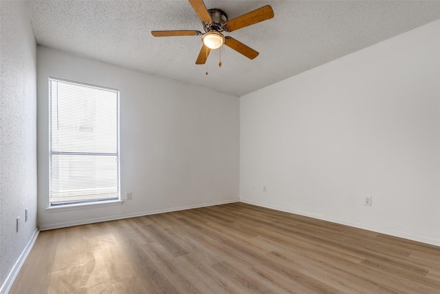 10051 Westpark Dr Unit 274, Houston, TX 77042 - unfurnished room with light wood-style floors, a textured ceiling, ceiling fan, and baseboards
