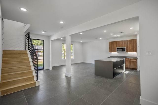 10728 Twin Oak Dr, Conroe, TX 77385 - kitchen featuring stainless steel microwave, brown cabinetry, a center island, recessed lighting, and open floor plan