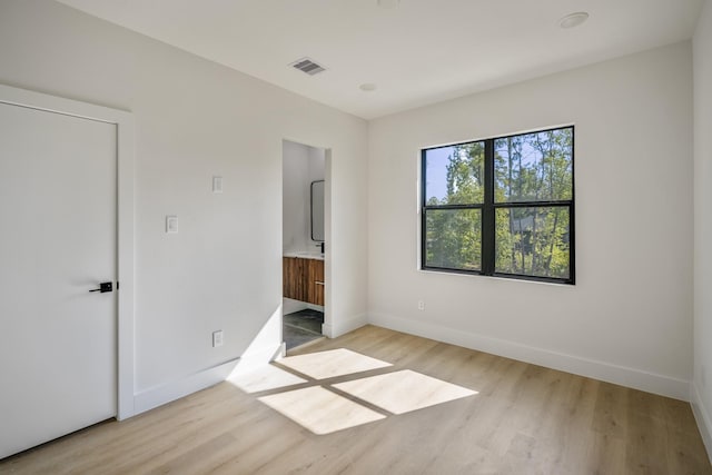 10728 Twin Oak Dr, Conroe, TX 77385 - unfurnished bedroom with wood finished floors, baseboards, and connected bathroom