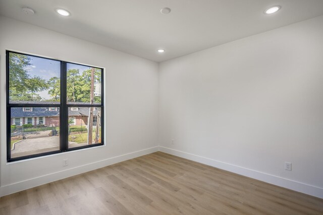 10728 Twin Oak Dr, Conroe, TX 77385 - empty room with light wood-style flooring, baseboards, recessed lighting, and a smoke detector