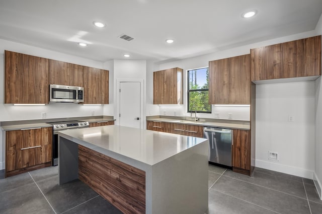 10728 Twin Oak Dr, Conroe, TX 77385 - kitchen with appliances with stainless steel finishes, brown cabinets, modern cabinets, and recessed lighting