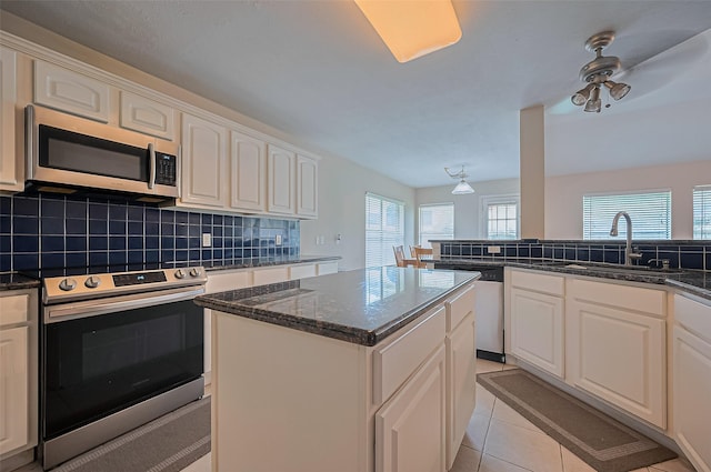 3619 Strartford Arms Ln, Sugar Land, TX 77498 - kitchen featuring stainless steel appliances, backsplash, a kitchen island, white cabinets, and dark stone countertops