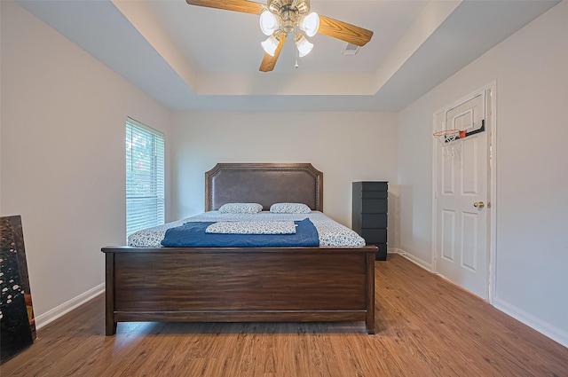 3619 Strartford Arms Ln, Sugar Land, TX 77498 - bedroom with a tray ceiling, wood finished floors, and a ceiling fan