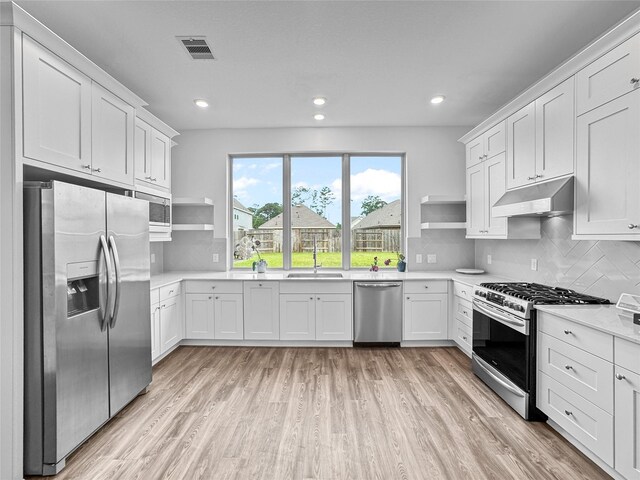 4326 Camden Springs Trl, Porter, TX 77365 - kitchen featuring stainless steel appliances, open shelves, under cabinet range hood, a sink, and recessed lighting