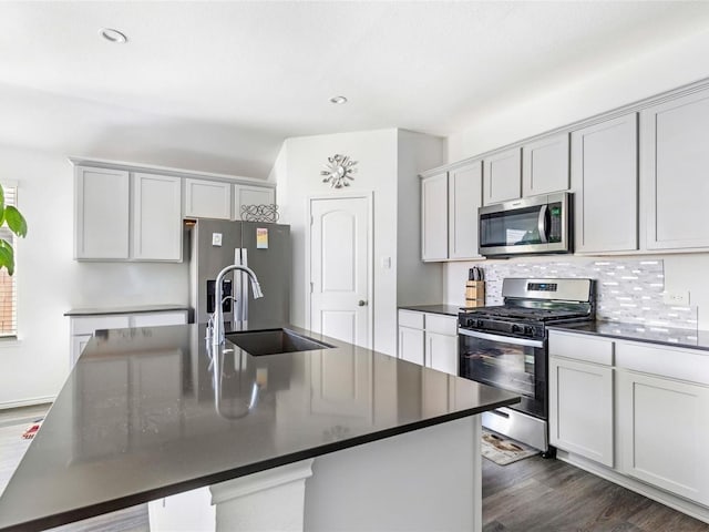 17718 Sommerset Falls Ln, Crosby, TX 77532 - kitchen featuring stainless steel appliances, a sink, dark countertops, dark wood-style flooring, and backsplash