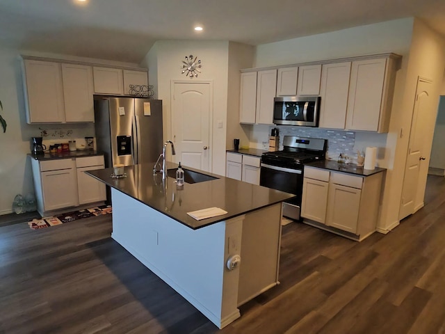 17718 Sommerset Falls Ln, Crosby, TX 77532 - kitchen with stainless steel appliances, recessed lighting, dark countertops, dark wood-type flooring, and a center island with sink