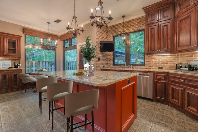 23 N Plum Crest Cir, The Woodlands, TX 77382 - kitchen featuring dishwasher, a chandelier, a breakfast bar area, light stone counters, and a kitchen island