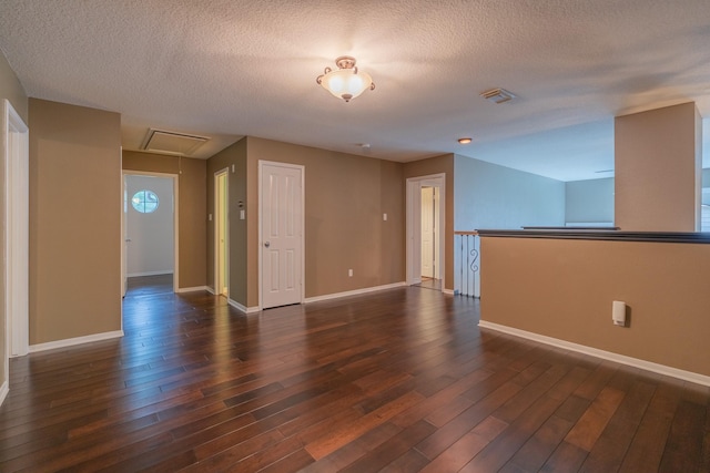 23 N Plum Crest Cir, The Woodlands, TX 77382 - spare room with dark wood-style floors, baseboards, a textured ceiling, and attic access