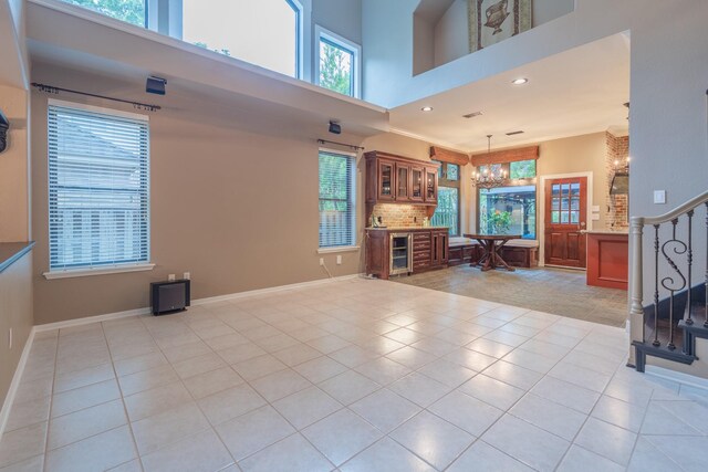 23 N Plum Crest Cir, The Woodlands, TX 77382 - living area with wine cooler, a chandelier, light tile patterned flooring, a towering ceiling, and healthy amount of natural light