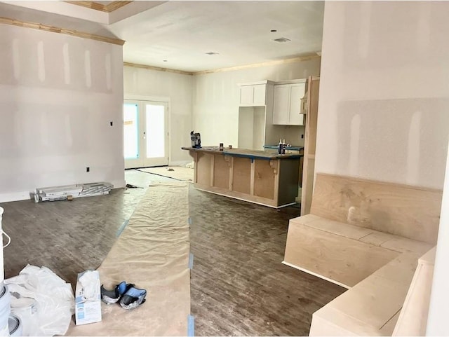10730 Vinson St, Beaumont, TX 77713 - kitchen featuring wood finished floors, a kitchen breakfast bar, white cabinets, crown molding, and a center island