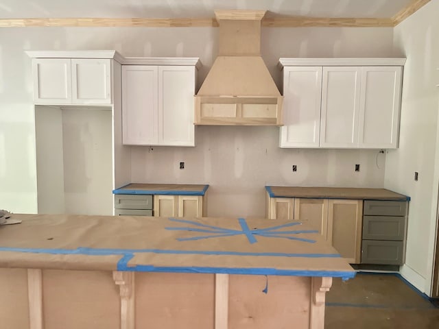 10730 Vinson St, Beaumont, TX 77713 - kitchen with custom exhaust hood, ornamental molding, white cabinets, and a center island