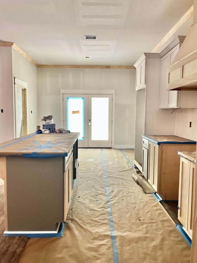 10730 Vinson St, Beaumont, TX 77713 - kitchen with wall chimney range hood, french doors, a center island, and crown molding