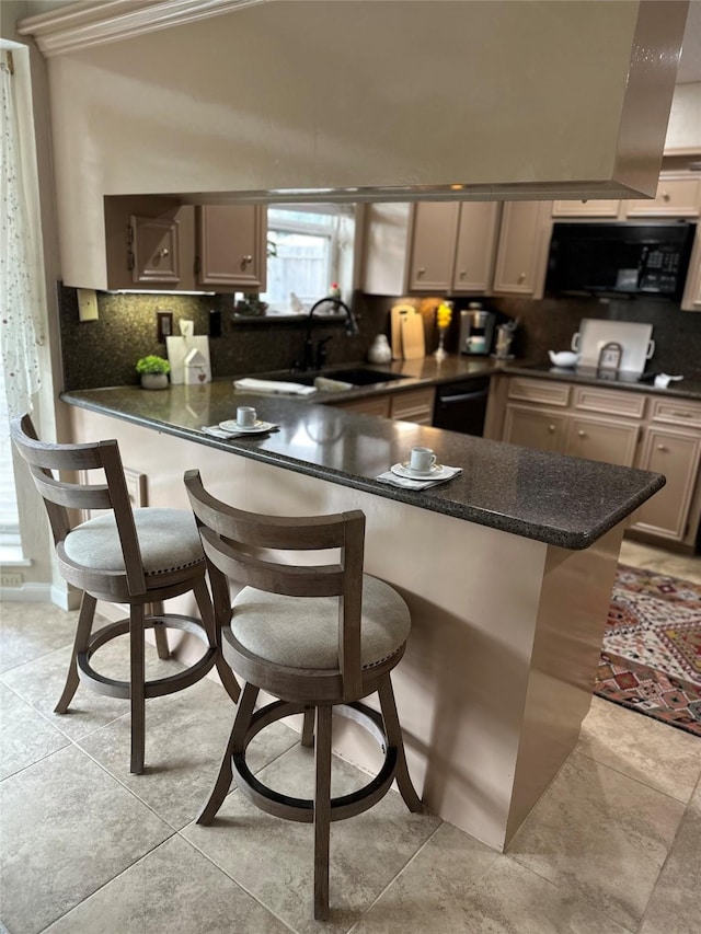 kitchen with black appliances, dark countertops, decorative backsplash, and a peninsula