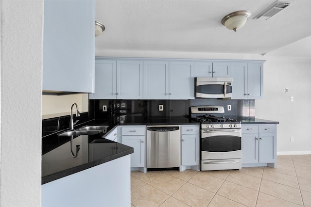 10911 Cedar Bridge St, Houston, TX 77075 - kitchen featuring stainless steel appliances, dark countertops, a sink, and light tile patterned floors