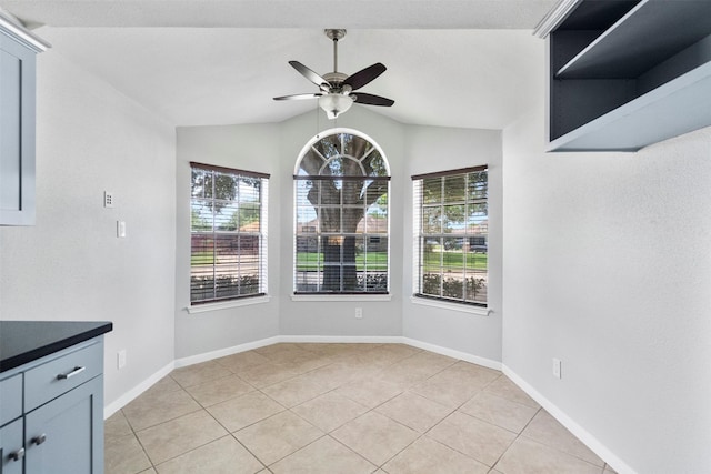 10911 Cedar Bridge St, Houston, TX 77075 - unfurnished dining area featuring a ceiling fan, light tile patterned flooring, vaulted ceiling, and baseboards