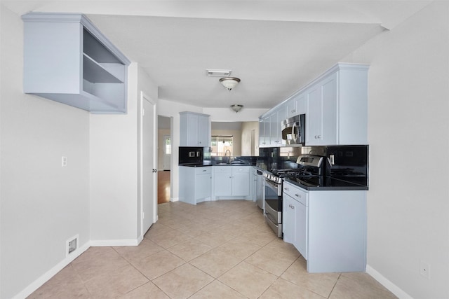 10911 Cedar Bridge St, Houston, TX 77075 - kitchen with stainless steel appliances, dark countertops, light tile patterned floors, and backsplash