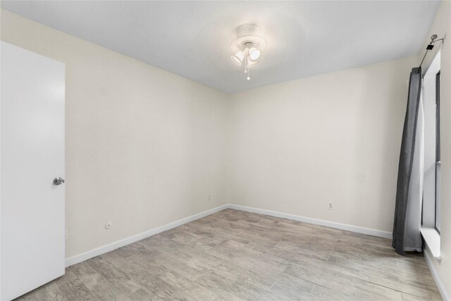 2601 S Braeswood Blvd S Unit 1403, Houston, TX 77025 - spare room featuring light wood finished floors, baseboards, and a barn door
