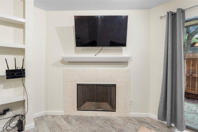 2601 S Braeswood Blvd S Unit 1403, Houston, TX 77025 - unfurnished living room with a fireplace, wood finished floors, and baseboards