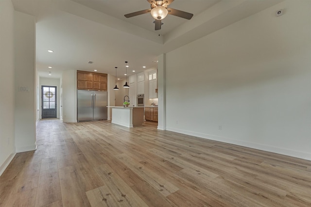 15611 Red Panda Rd, Conroe, TX 77302 - unfurnished living room featuring a ceiling fan, light wood-type flooring, recessed lighting, a sink, and baseboards