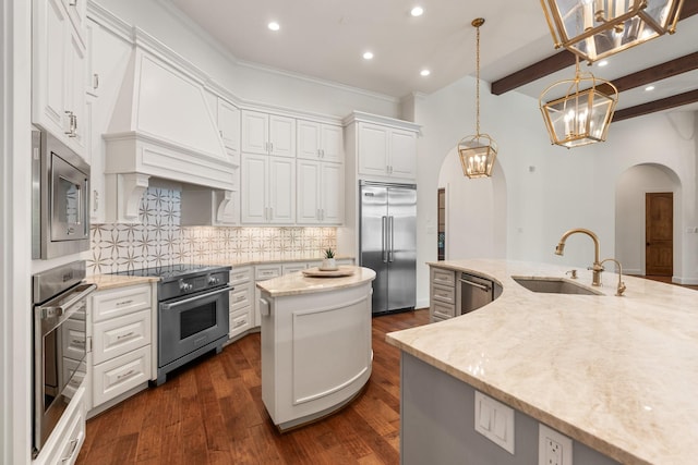 3 Maroon Creek Ct, The Woodlands, TX 77389 - kitchen with built in appliances, arched walkways, a sink, a kitchen island with sink, and recessed lighting