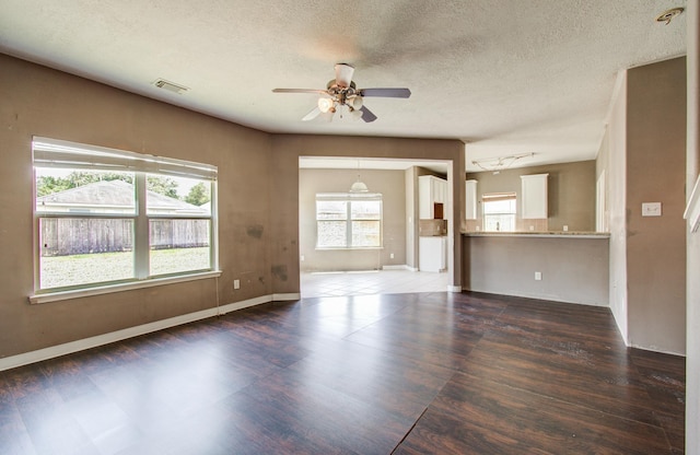 1418 High Thicket Ct, Spring, TX 77373 - unfurnished living room with dark wood-style floors, ceiling fan, baseboards, and a textured ceiling