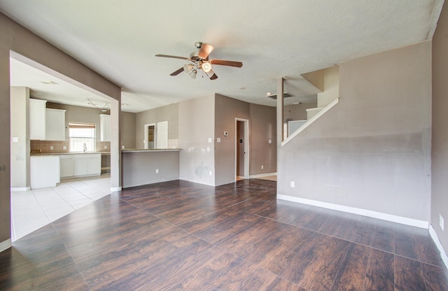 1418 High Thicket Ct, Spring, TX 77373 - unfurnished living room featuring a ceiling fan, wood finished floors, baseboards, a sink, and stairway