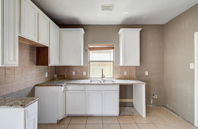 1418 High Thicket Ct, Spring, TX 77373 - kitchen featuring a sink, tasteful backsplash, light tile patterned floors, and white cabinets