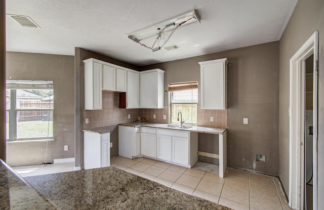 1418 High Thicket Ct, Spring, TX 77373 - kitchen featuring a sink, light tile patterned floors, backsplash, a textured ceiling, and white cabinets