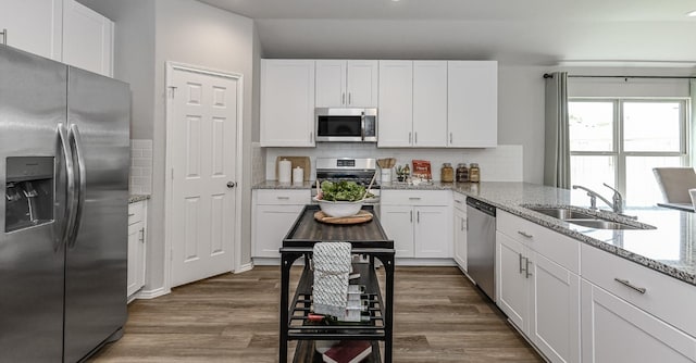 310 Bandit Cove Ct, Crosby, TX 77354 - kitchen with stainless steel appliances, decorative backsplash, and white cabinets