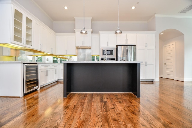 11028 Avenu Malkenu Ave, Houston, TX 77043 - kitchen featuring appliances with stainless steel finishes, wine cooler, arched walkways, white cabinets, and crown molding