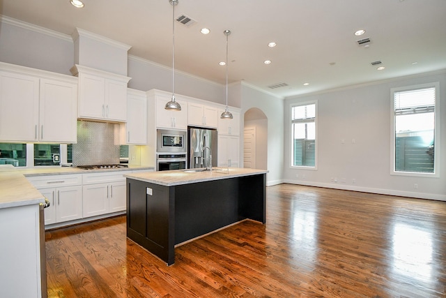 11028 Avenu Malkenu Ave, Houston, TX 77043 - kitchen featuring appliances with stainless steel finishes, arched walkways, crown molding, light countertops, and decorative backsplash