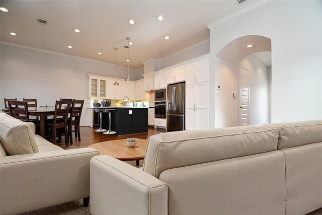 11028 Avenu Malkenu Ave, Houston, TX 77043 - living room with ornamental molding, recessed lighting, arched walkways, and dark wood-type flooring
