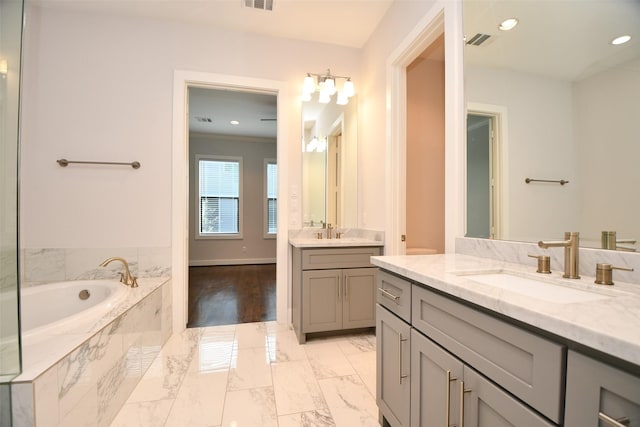 11028 Avenu Malkenu Ave, Houston, TX 77043 - bathroom featuring a bath, marble look tile flooring, two vanities, recessed lighting, and baseboards
