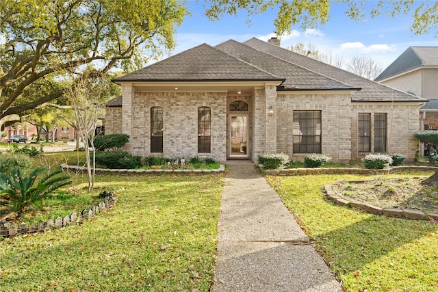 1015 Flagmore Dr, Katy, TX 77450 - french country inspired facade with a front lawn, roof with shingles, brick siding, and a chimney