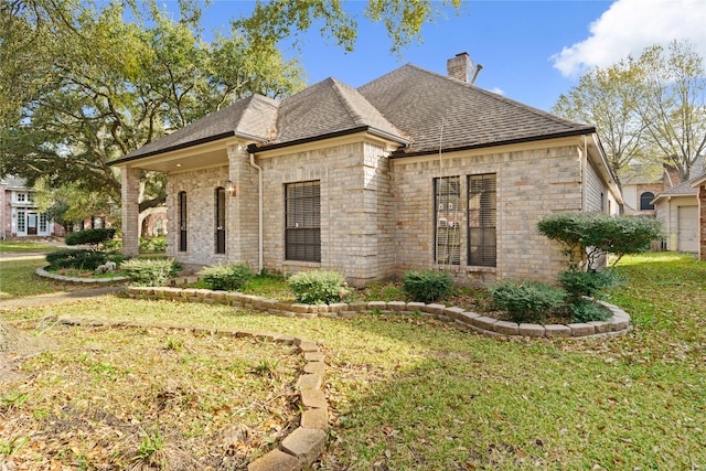 1015 Flagmore Dr, Katy, TX 77450 - view of side of property with a lawn, a chimney, brick siding, and roof with shingles