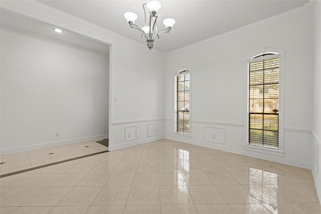 1015 Flagmore Dr, Katy, TX 77450 - empty room featuring light tile patterned floors, ornamental molding, a chandelier, a wainscoted wall, and baseboards