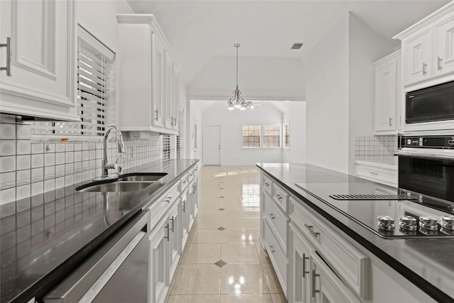 1015 Flagmore Dr, Katy, TX 77450 - kitchen with black appliances, a sink, white cabinets, a chandelier, and decorative backsplash