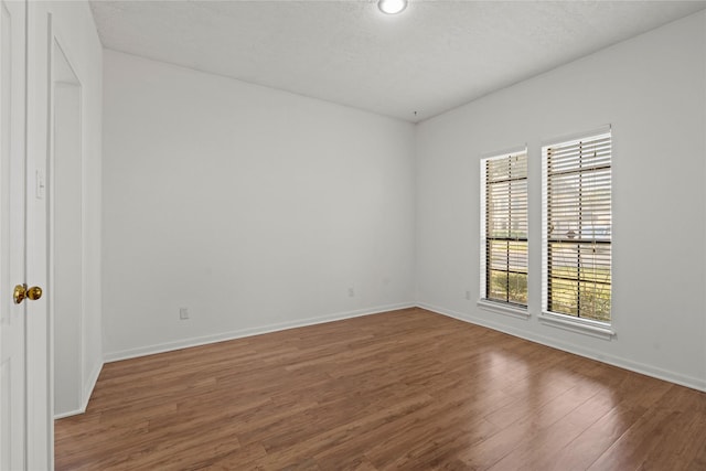 1015 Flagmore Dr, Katy, TX 77450 - empty room featuring wood finished floors, baseboards, and a textured ceiling