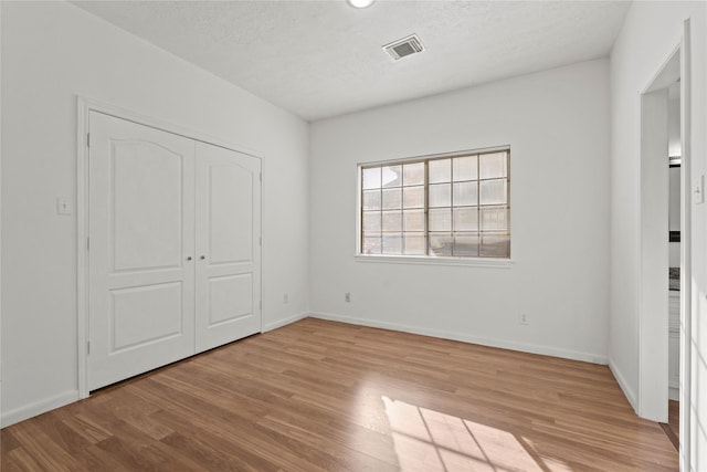1015 Flagmore Dr, Katy, TX 77450 - unfurnished bedroom with wood finished floors, baseboards, a closet, and a textured ceiling