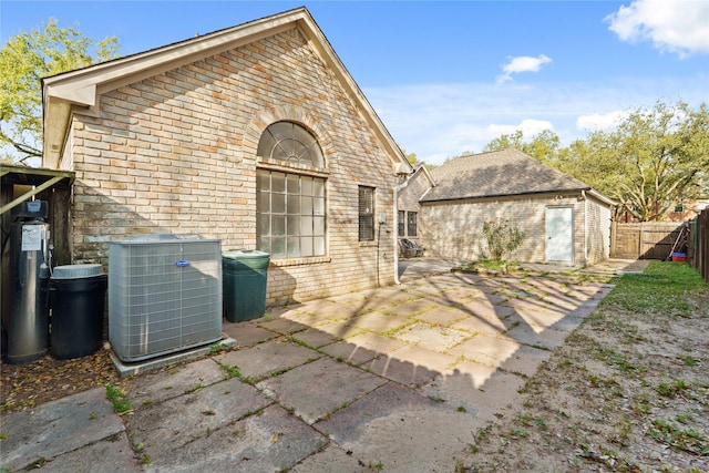 1015 Flagmore Dr, Katy, TX 77450 - back of property with central AC, brick siding, and a patio area