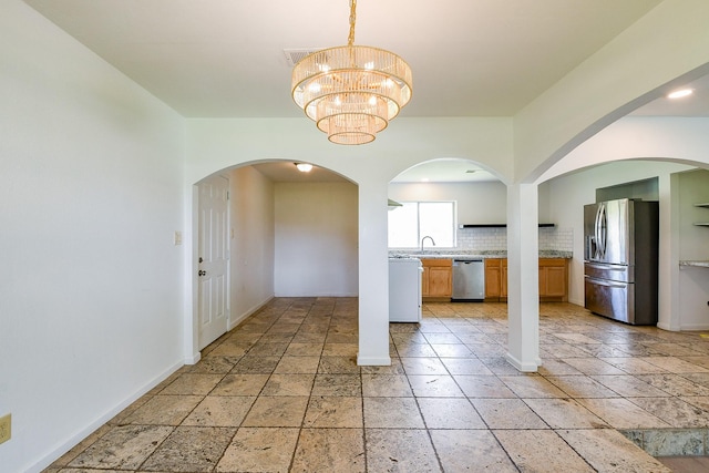 406 Shadylawn St, Shoreacres, TX 77571 - kitchen with appliances with stainless steel finishes, baseboards, tasteful backsplash, arched walkways, and a chandelier