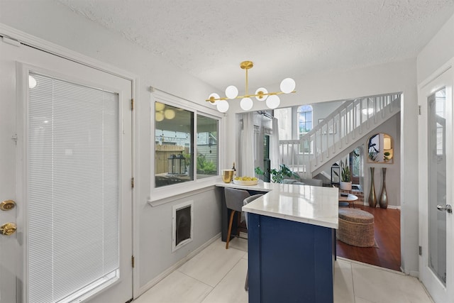 8515 Cold Lake Dr, Houston, TX 77088 - kitchen featuring a textured ceiling, a chandelier, light tile patterned floors, light countertops, and hanging light fixtures