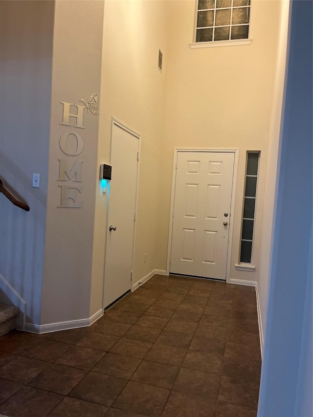 14226 Silver Hollow Ln, Houston, TX 77082 - foyer featuring a towering ceiling, stairs, baseboards, and dark tile patterned flooring