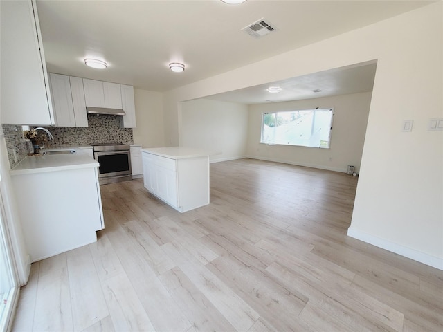 9926 Tangiers Rd, Houston, TX 77041 - kitchen with electric range, a sink, open floor plan, under cabinet range hood, and light countertops